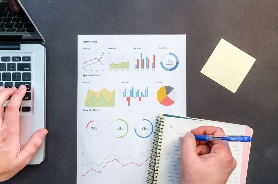 A bird’s-eye view of charts and a smartphone in an office, highlighting data analytics.